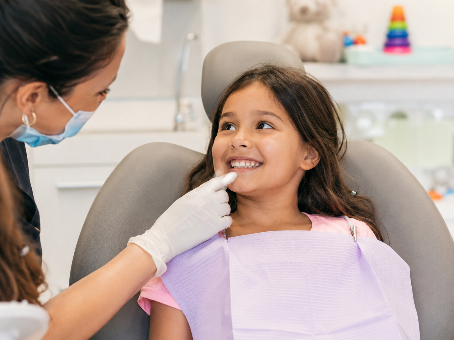 Child with newly erupted permanent front teeth during a pediatric dental visit.
