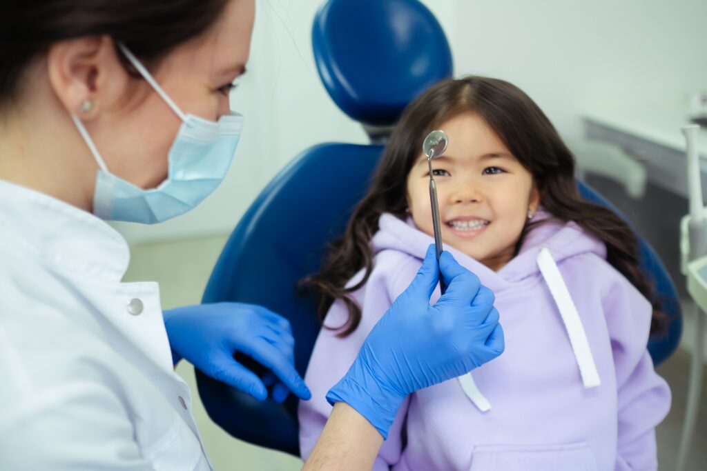 Smiling child talking with a dental professional during a preventive dental visit